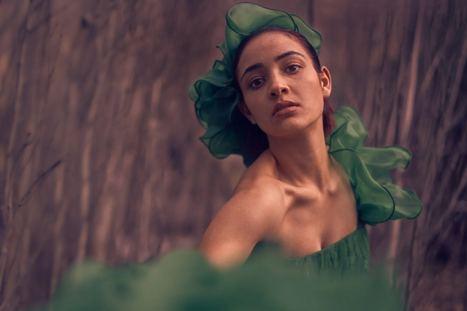 A woman in a flowing green headpiece