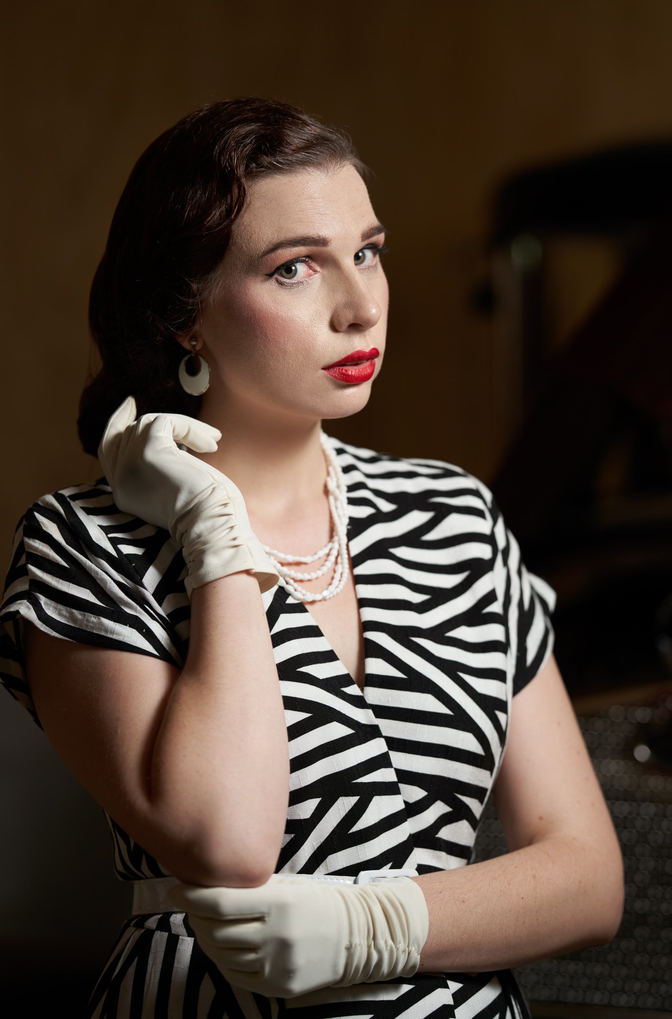 A woman in a zebra-print dress and white gloves