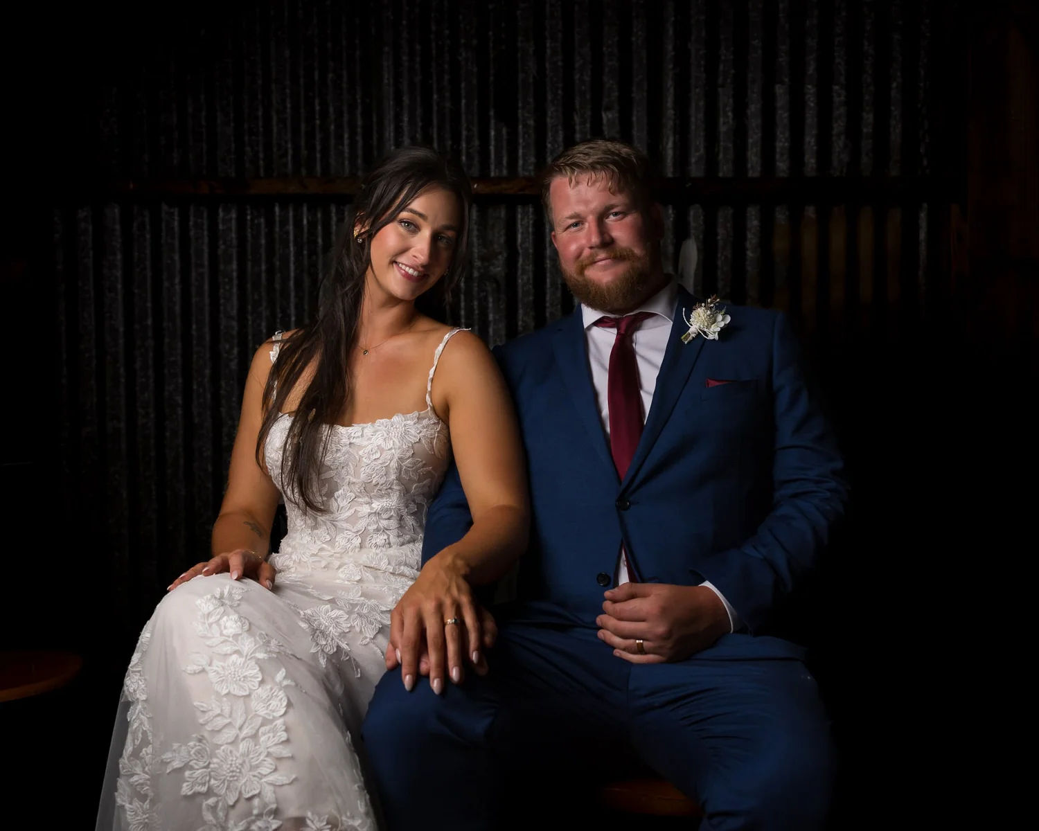 A couple seated together in a dramatic evening portrait