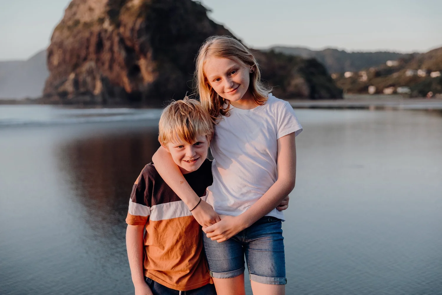 A brother and sister hug on the beach
