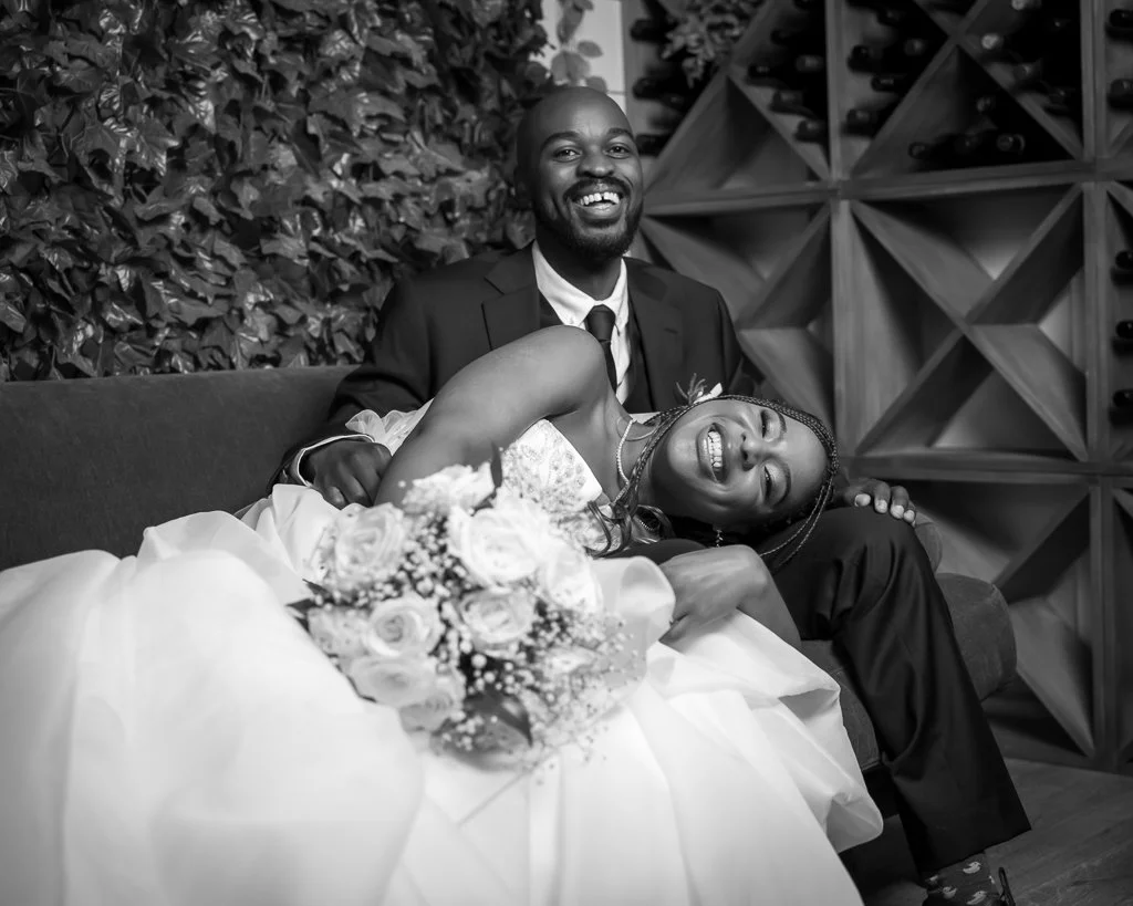 Black and white photo of a couple relaxing together on a leather sofa