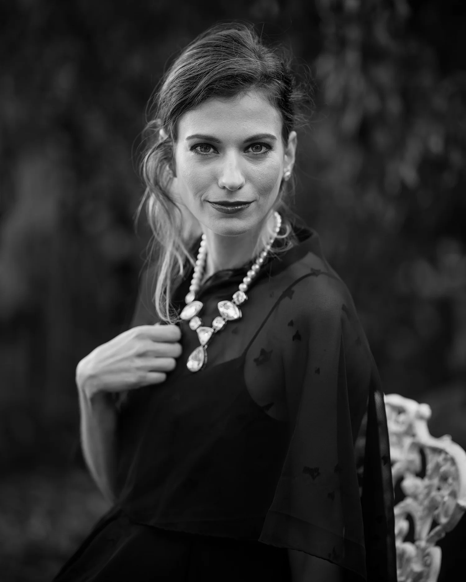 Black and white portrait of a woman in a statement necklace