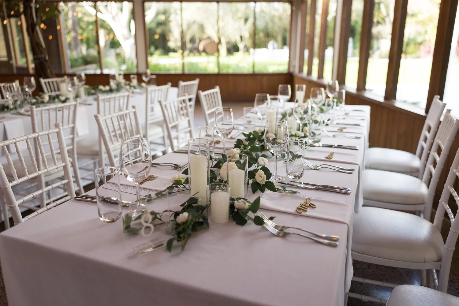 A long reception table with greenery and candles