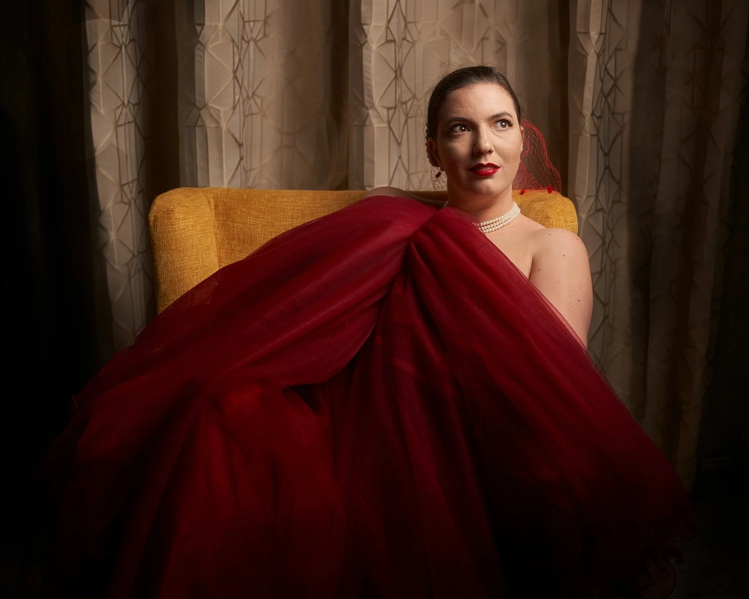 A woman reclining in a sweeping red gown