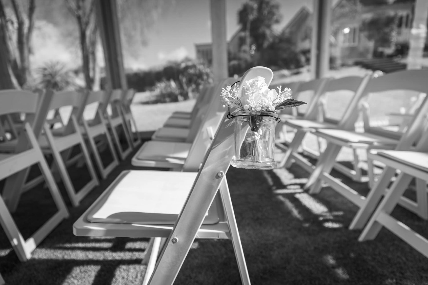 Black and white photo of a ceremony chair decorated with flowers