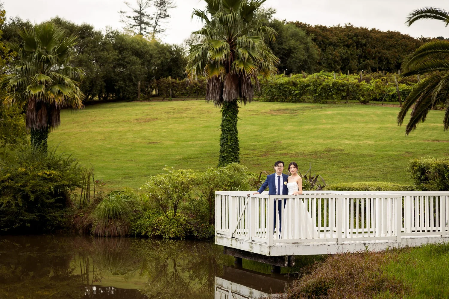 A couple on the lakeside rotunda surrounded by palms