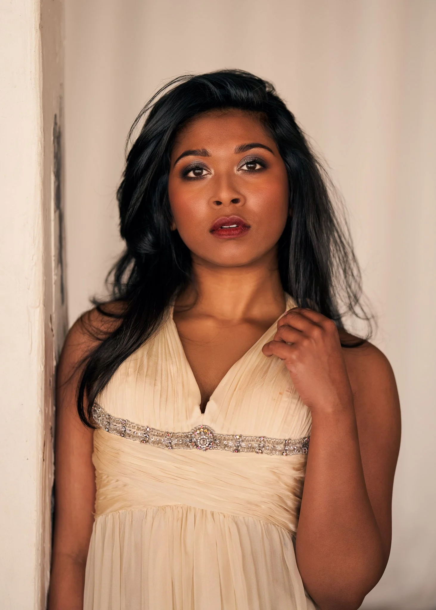 A woman in a cream gown with long dark hair