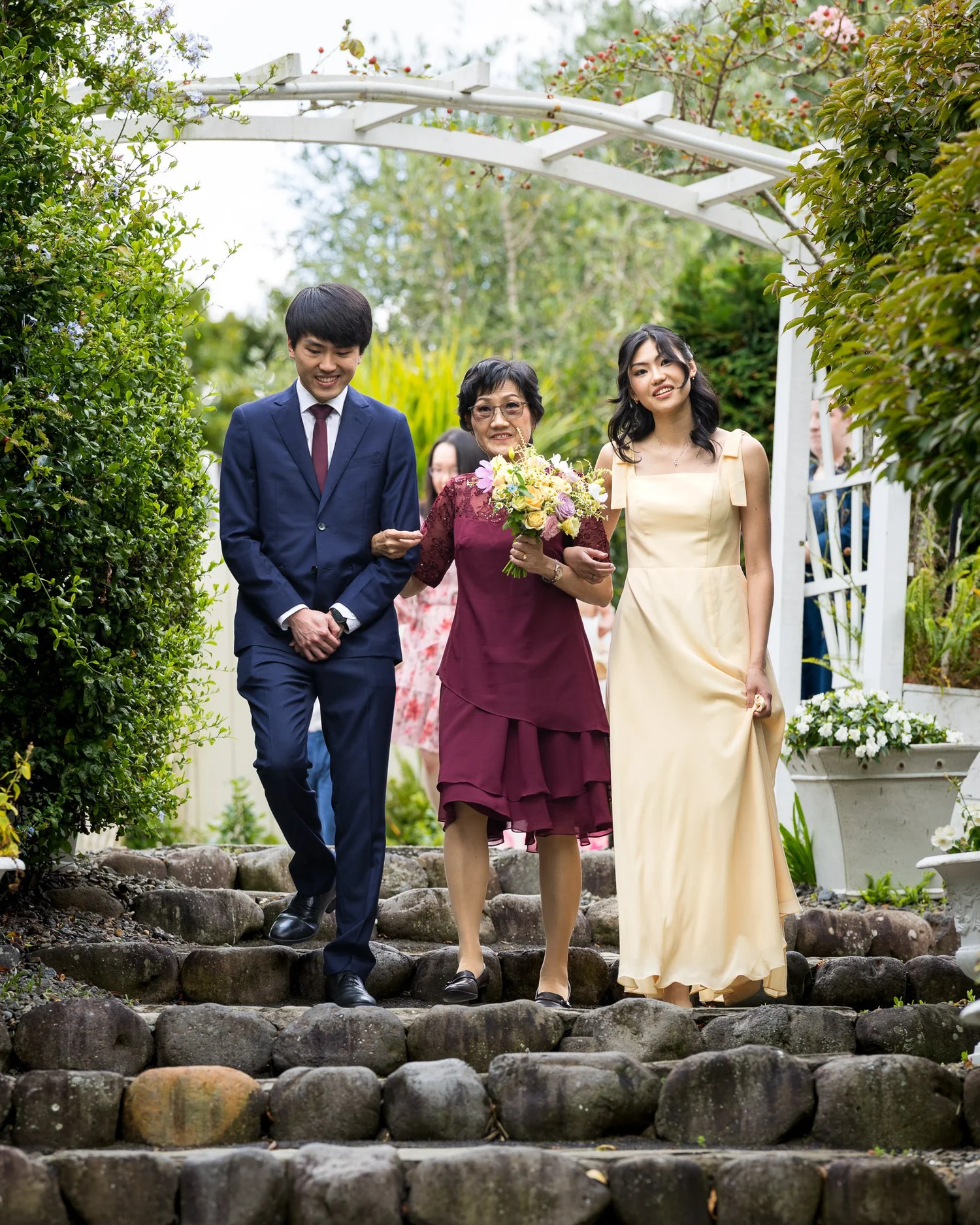 The bridal party walks down the stone steps