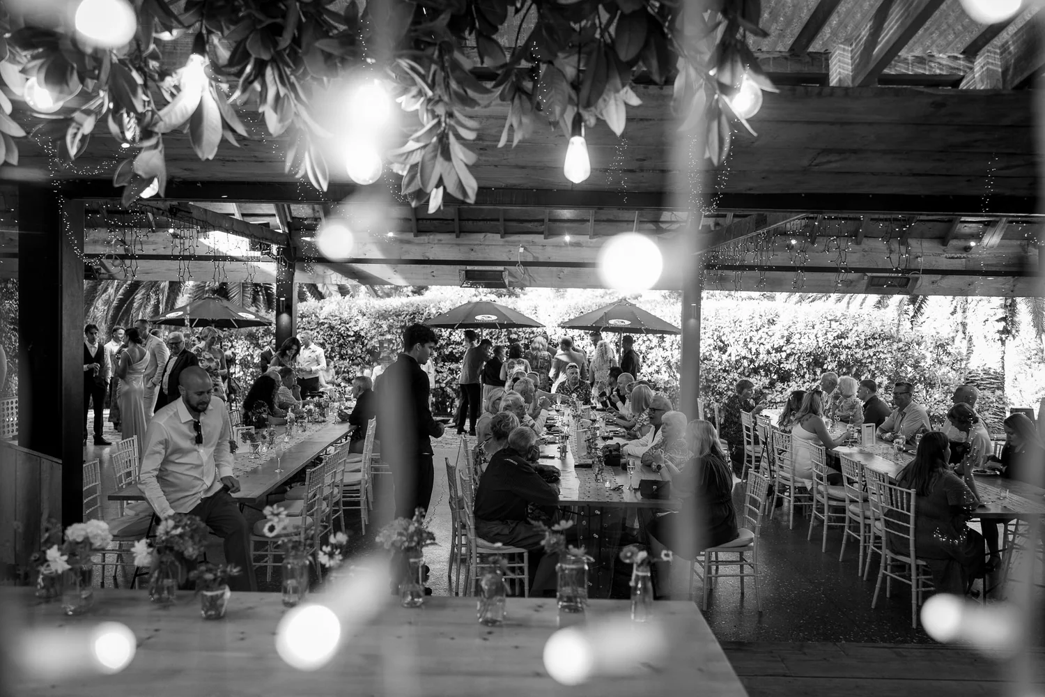 Black and white photo of guests at the reception under the barn
