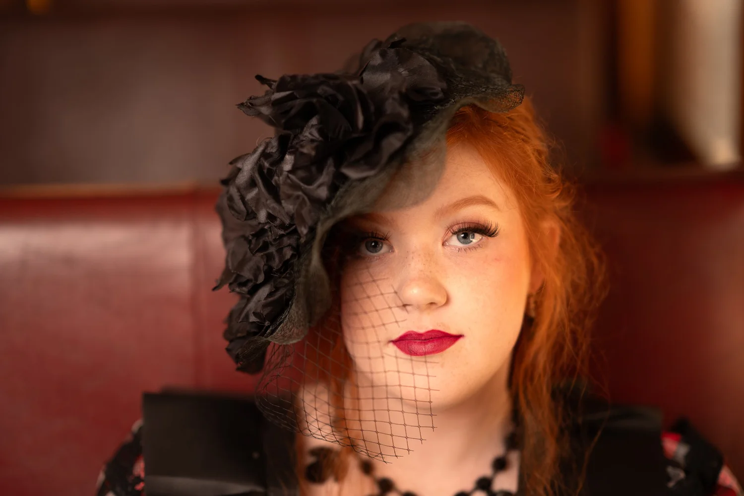 A woman in a black hat with a net veil