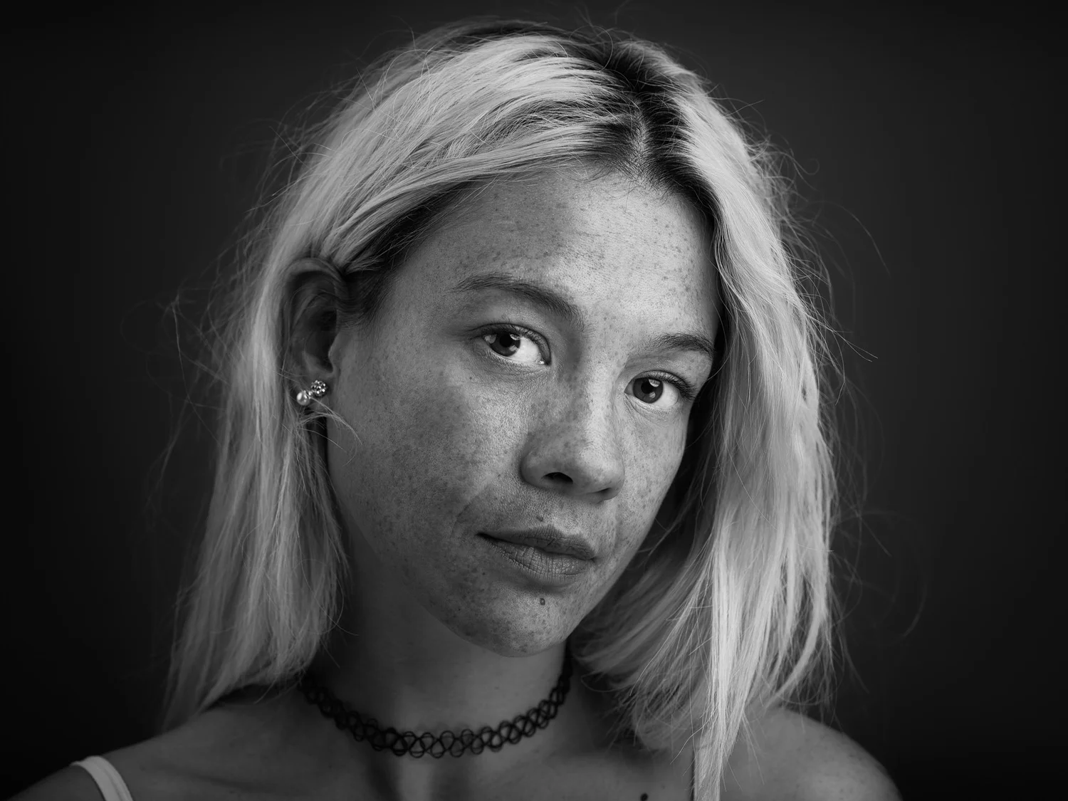 Black and white portrait of a blonde woman with a choker