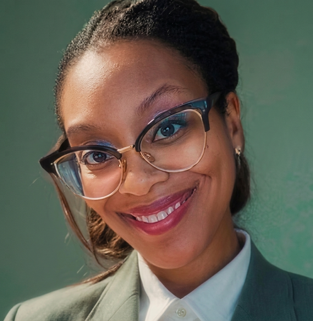 Close-up of a smiling woman wearing glasses and a business suit.