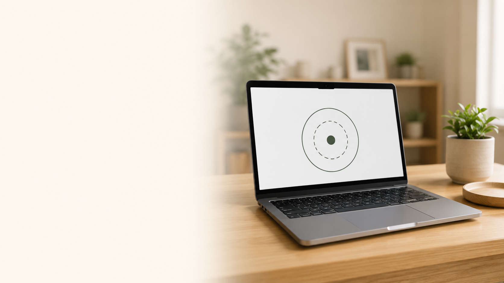 Laptop on a wooden desk displaying a target symbol, with a potted plant and a wooden tray nearby, in a well-lit room.