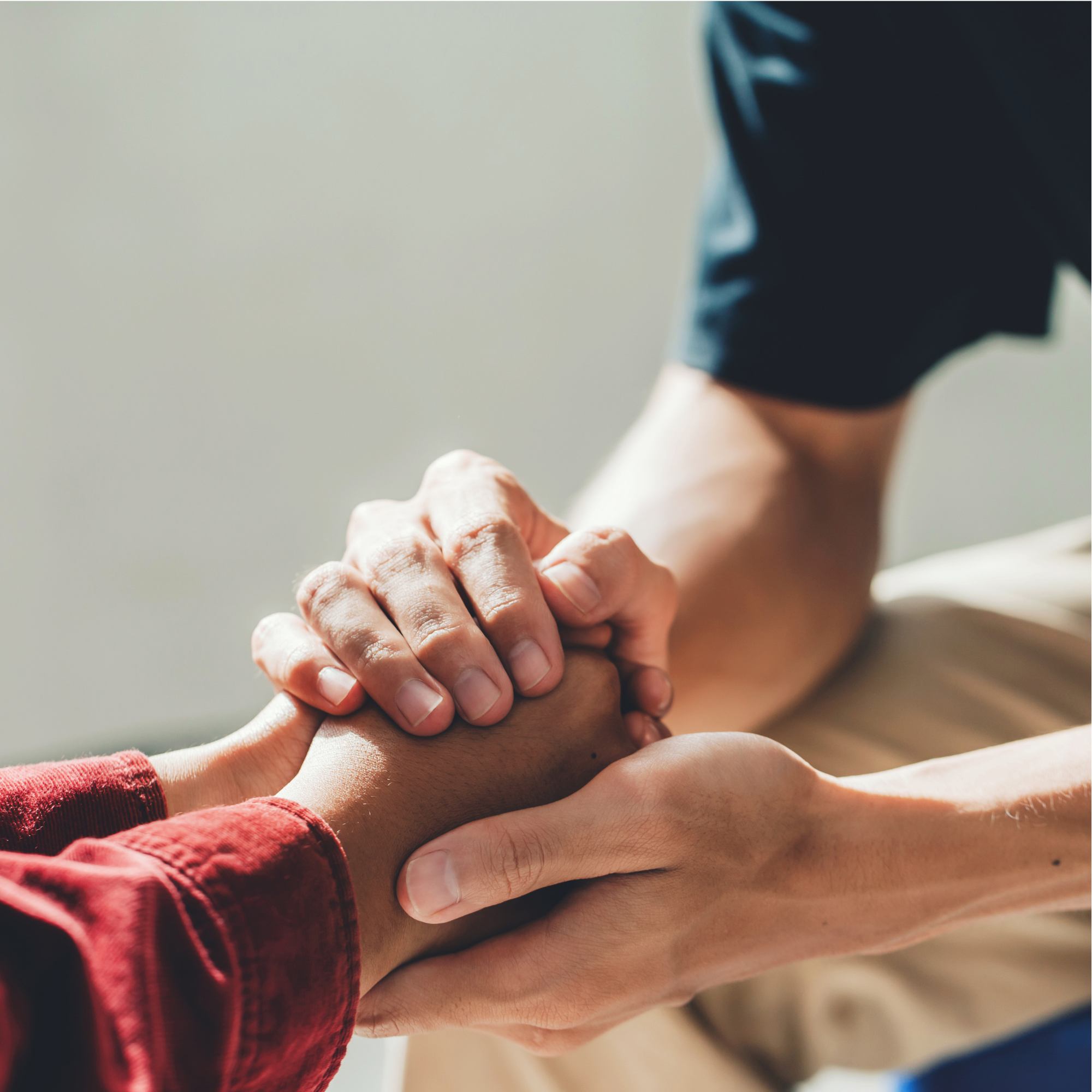 Close-up of multiple hands stacked together, symbolizing unity and teamwork.