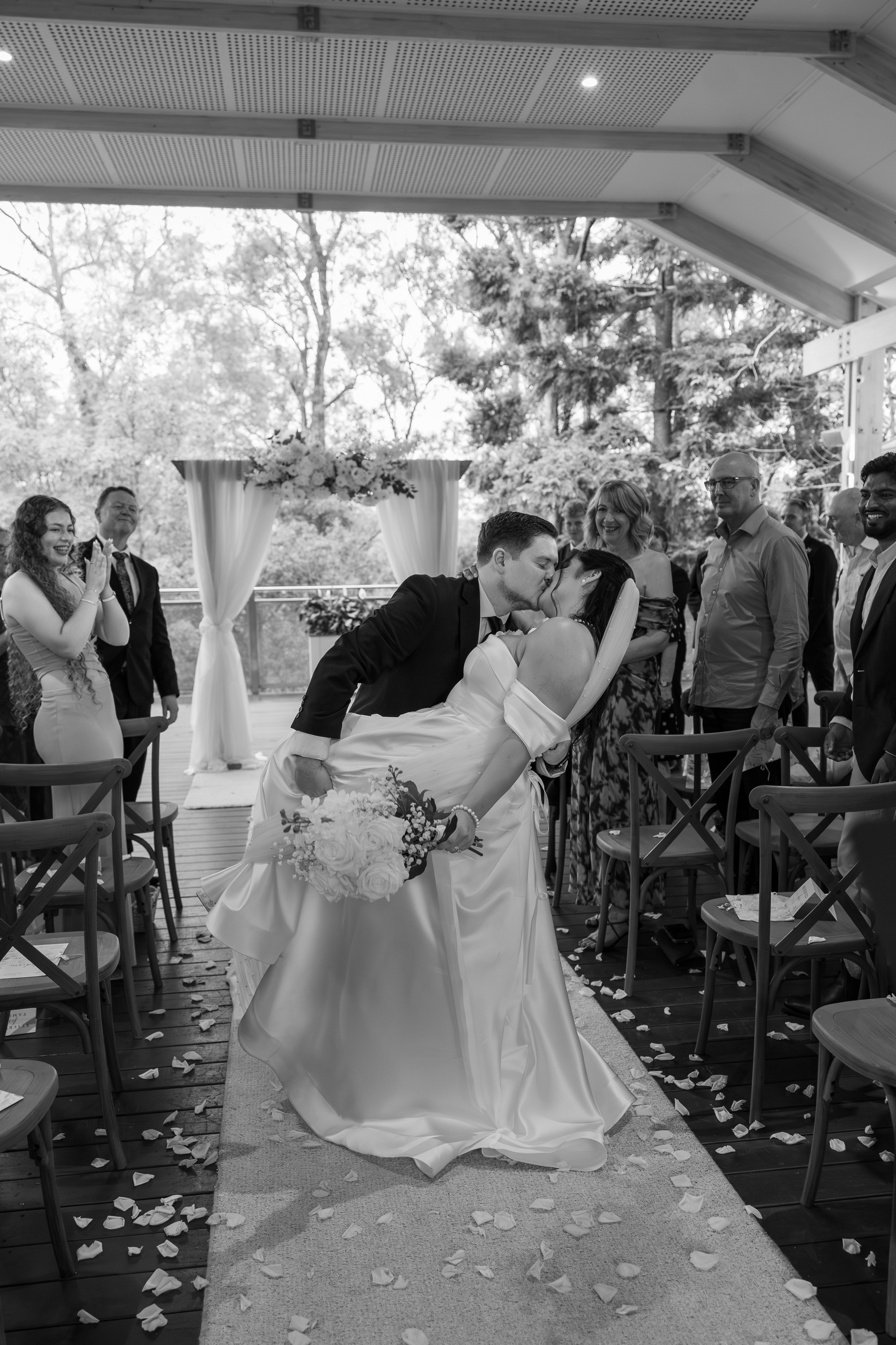Brisbane based wedding photographer capturing image of newlywed kissing half way down the alter. Romantic timless candid wedding photography in Brisbane. Walkabout creek discovery centre wedding