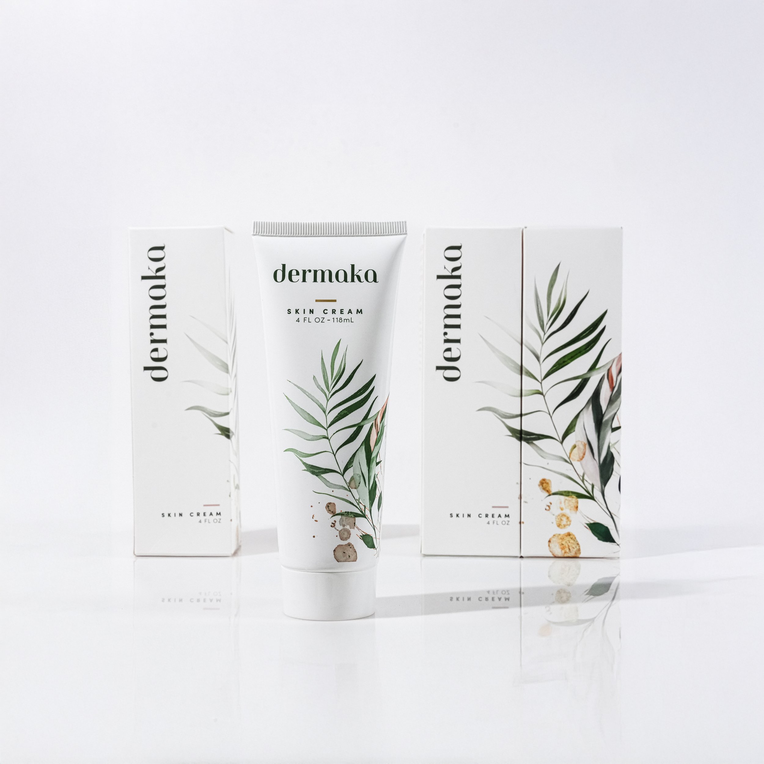 Dermapka skin cream tube in front of two boxes with botanical illustrations on a white background.