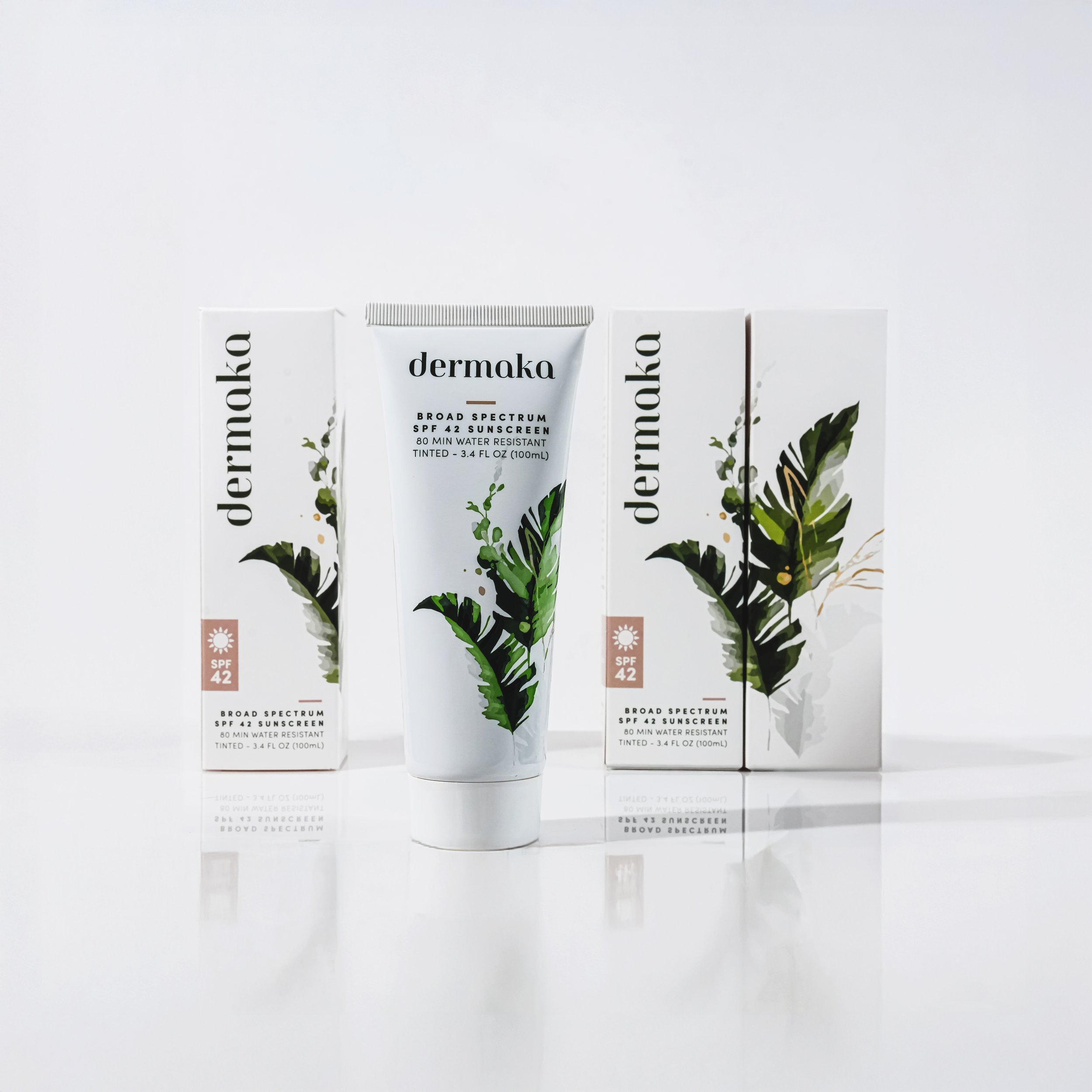 A skincare product called Derma with its box and tube. Both feature botanical illustrations and SPF 42 written on them.