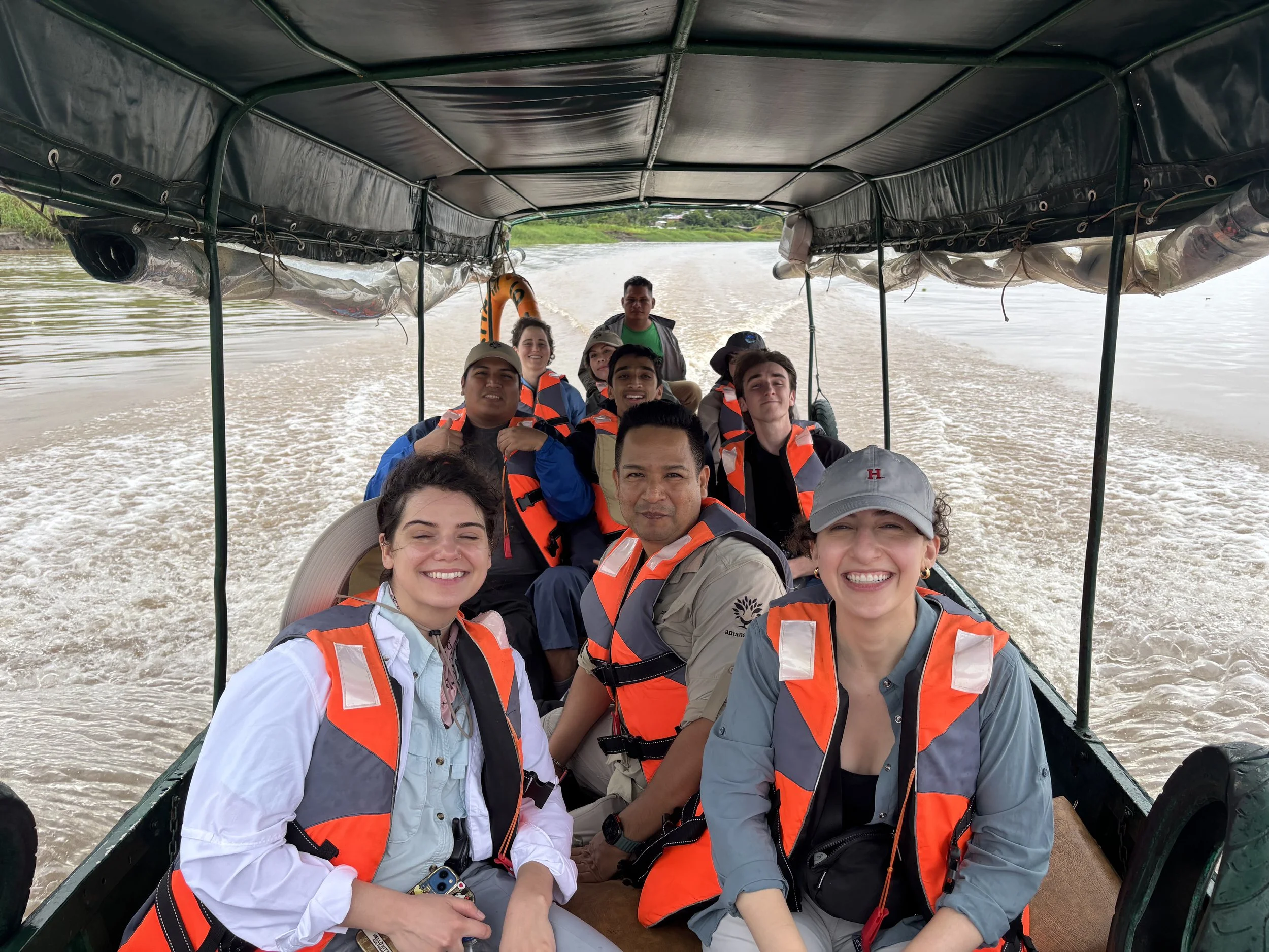 Hannah and Anna ride down the Amazon River to sampling sites, along with Roosevelt from Amanatari and students from the Harvard-UTEC J-term program on One Health (January 2026).