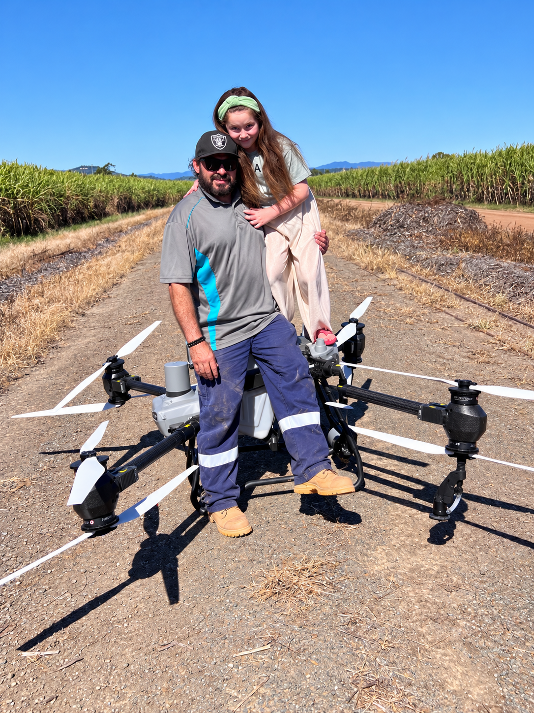 Rob and his daughter with an agricultural drone beside a sugarcane field in the Whitsundays.