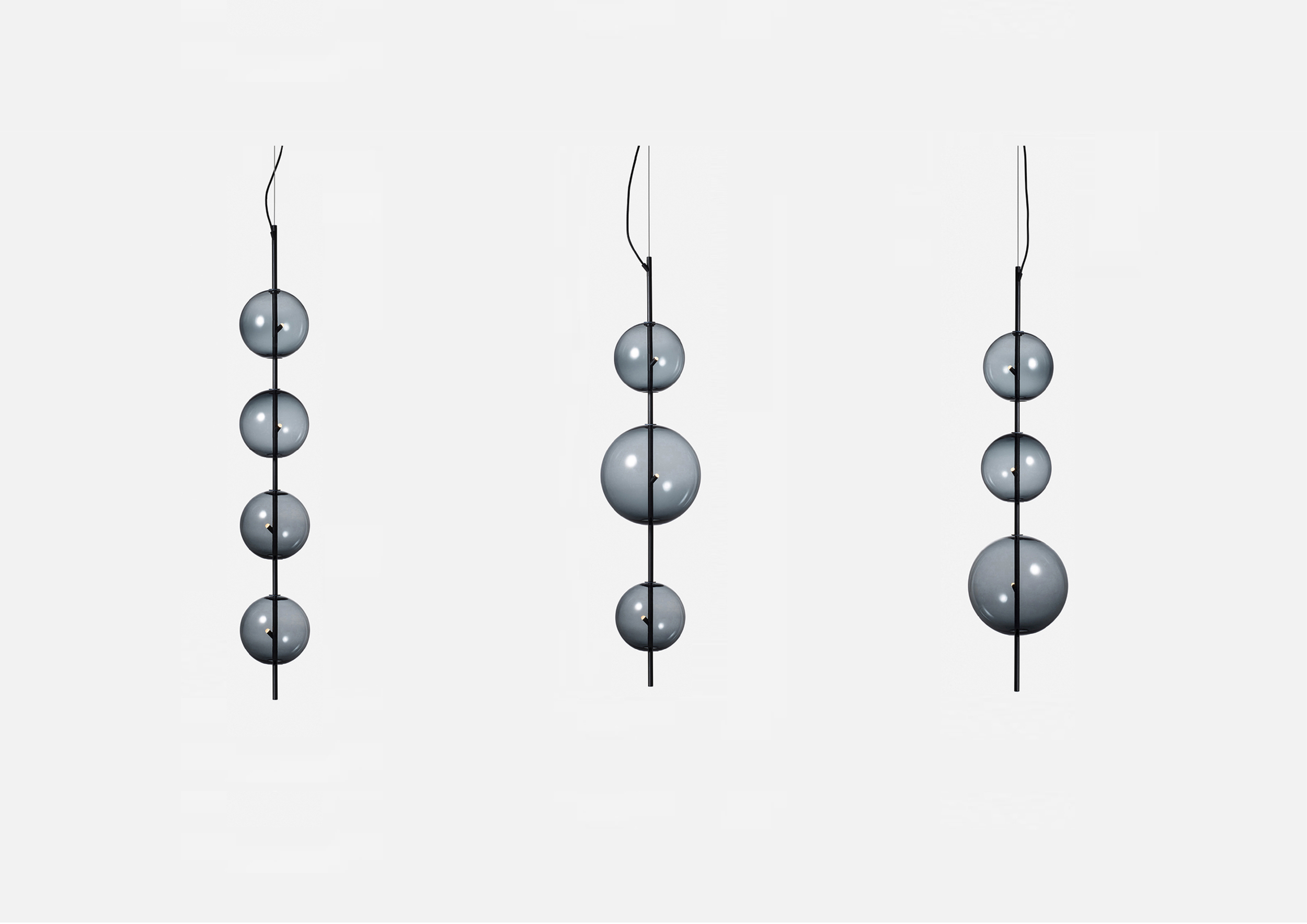 Three modern hanging pendant lights with five metallic spheres each, suspended from black cords against a white background.