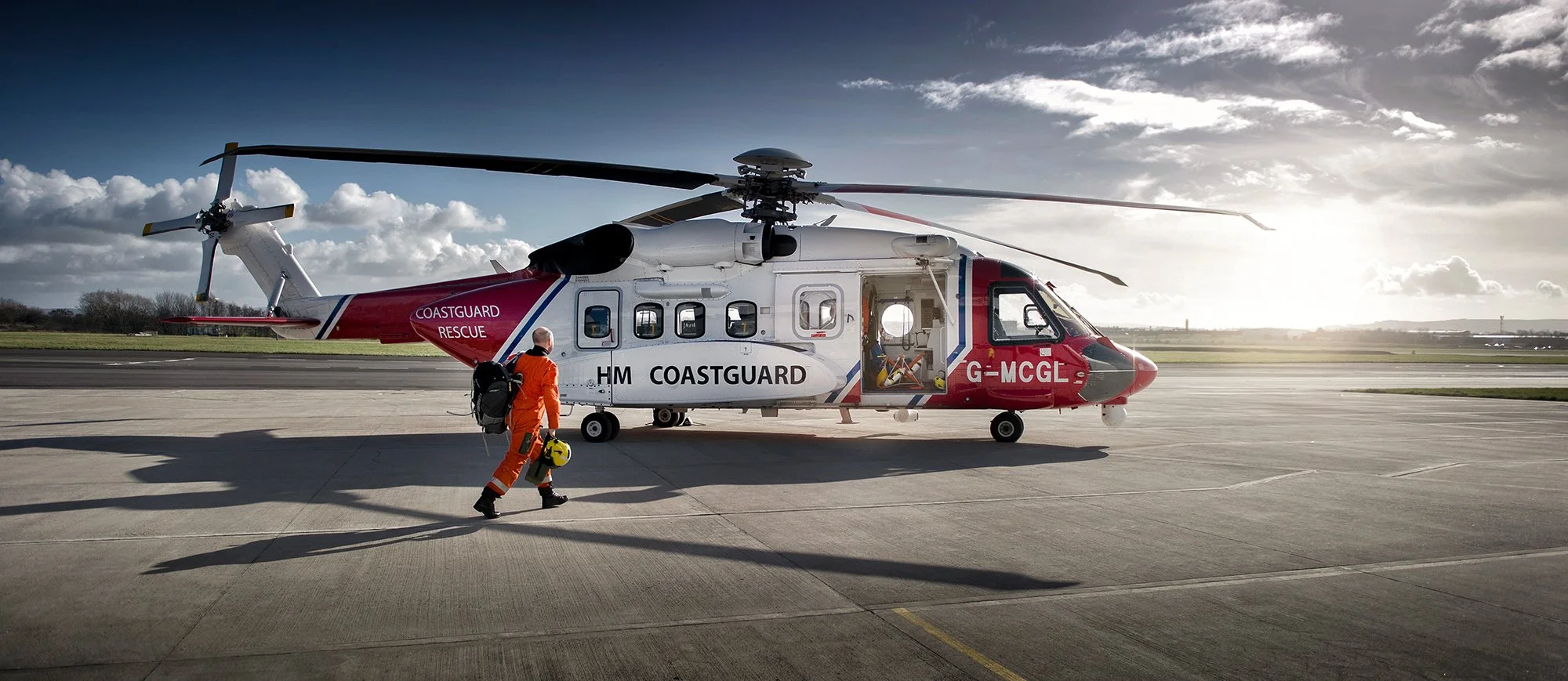 HM Coastguard Search and Rescue helicopter pilot walking to helicopter.