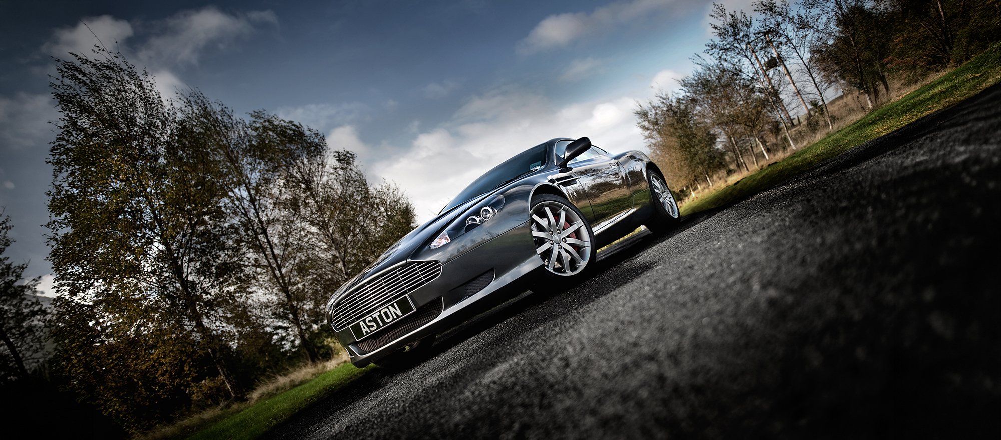 Aston Martin DB9 dramatic photograph on country road.