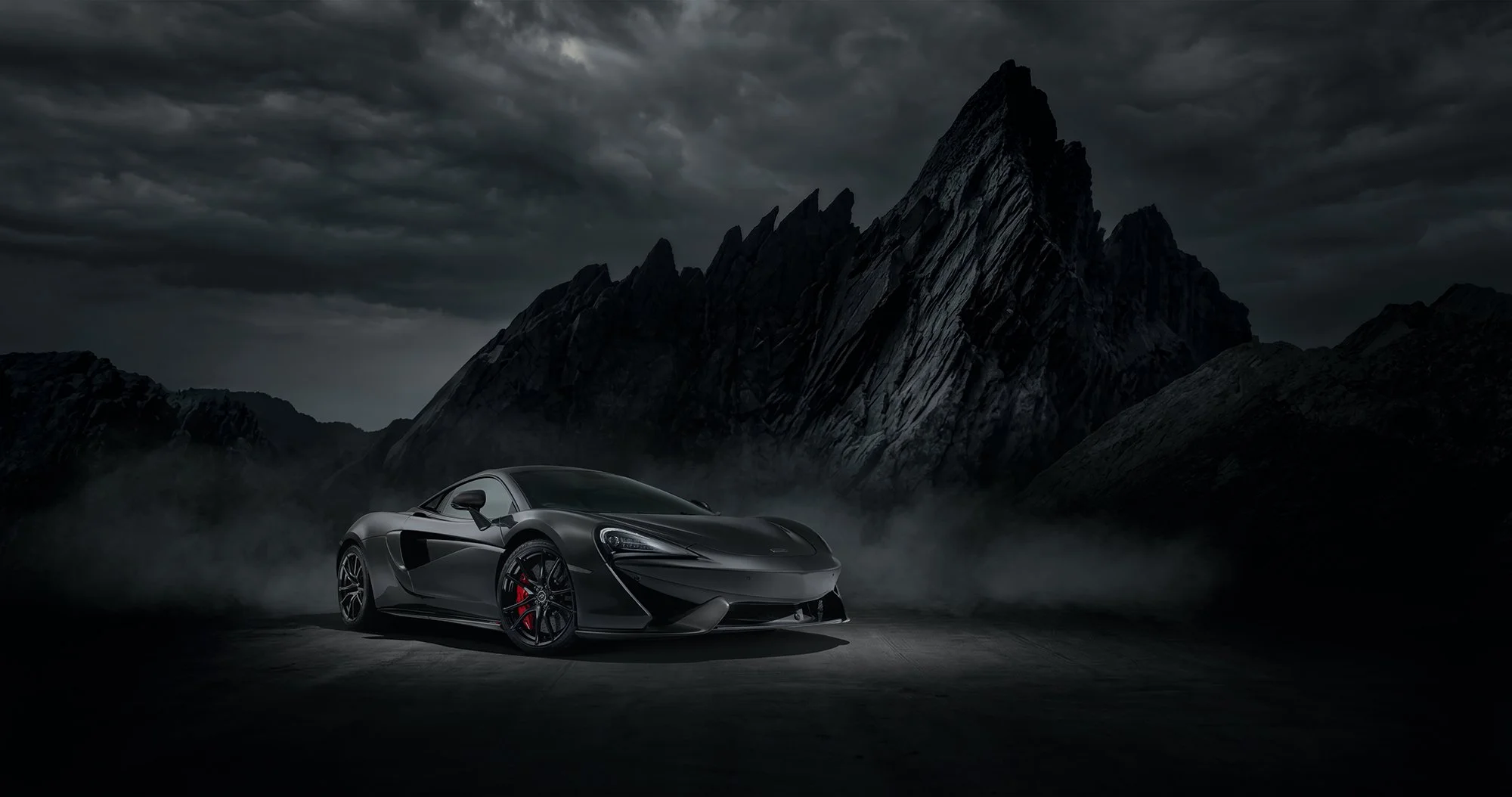 McLaren with dramatic rocks at night 