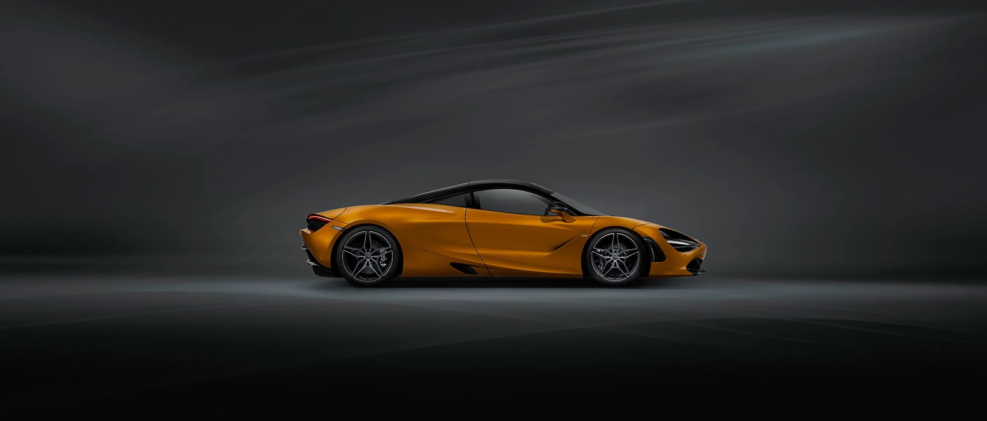 Profile view of a McLaren car in dark studio scene.