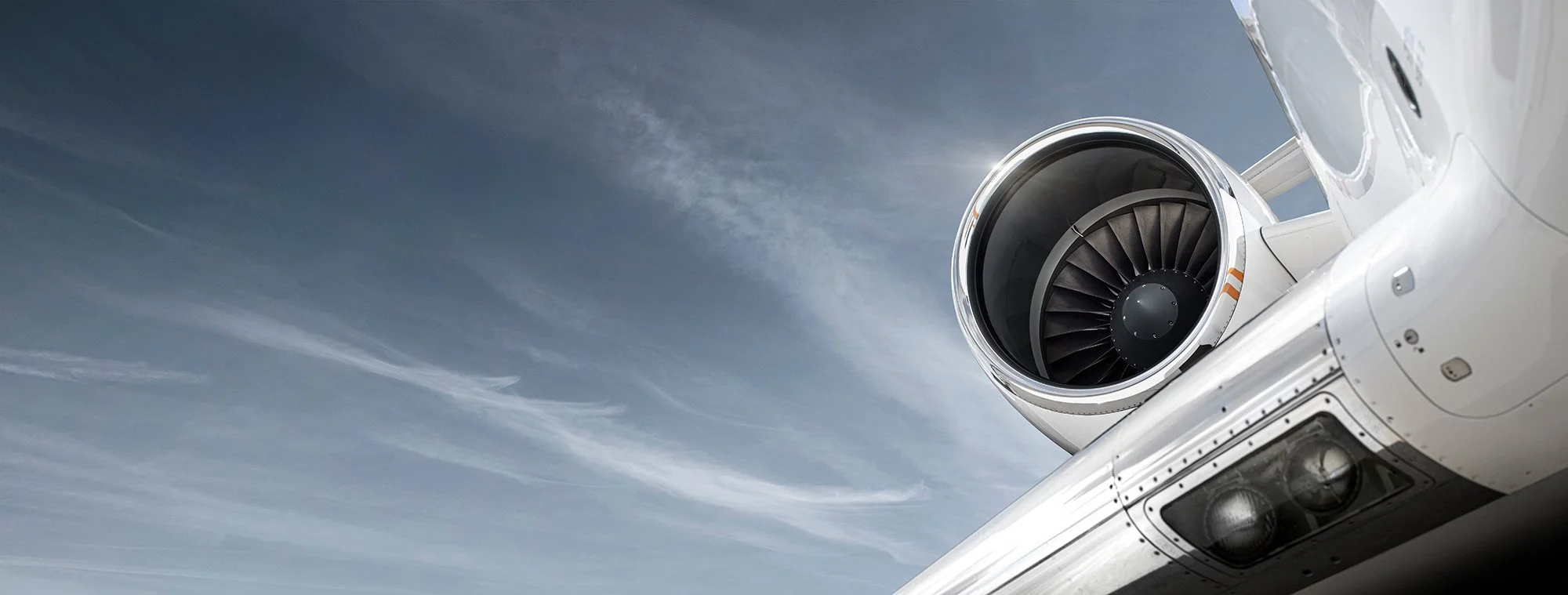 Private jet engine set against a blue sky, aviation photography.