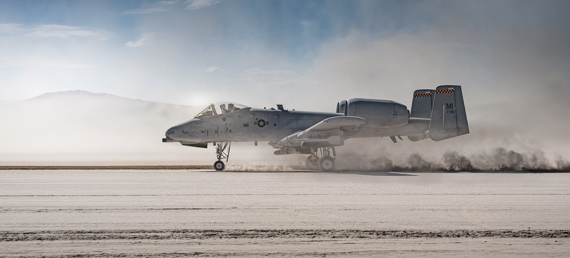 Military aircraft landing on sand in desert