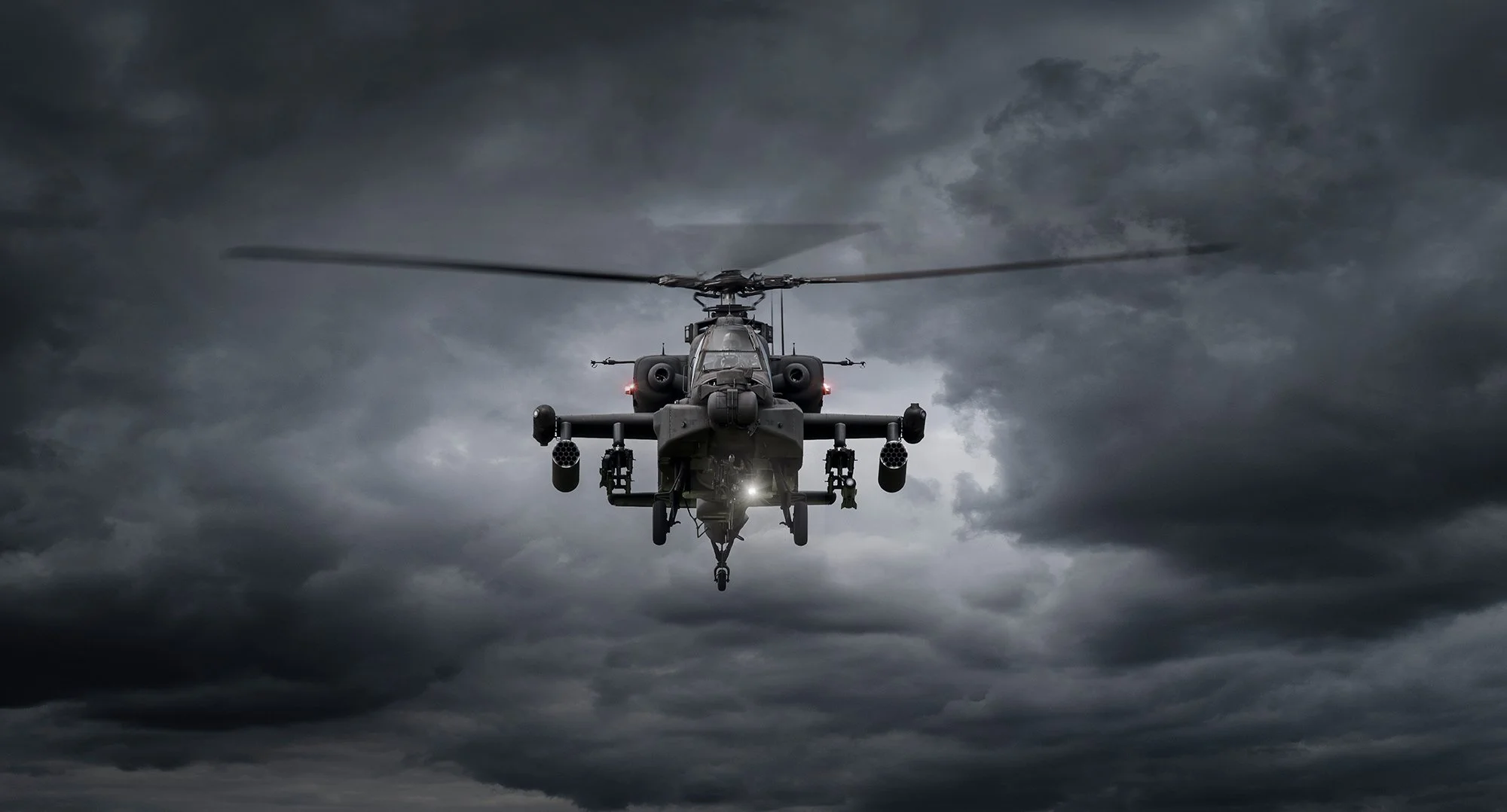 Apache helicopter hovering with dramatic sky in background