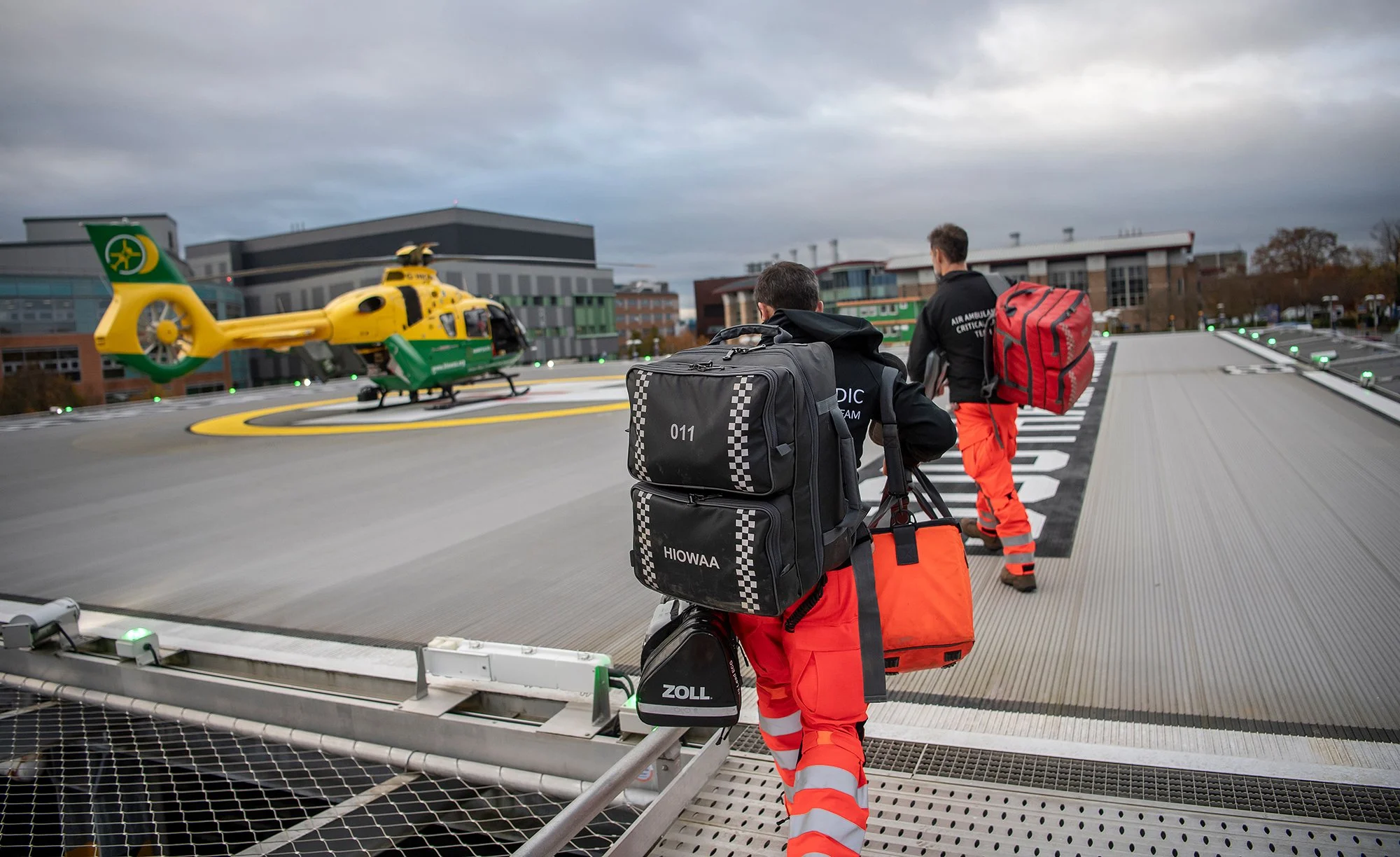Air Ambulance crew walking to helicopter on landing pad.