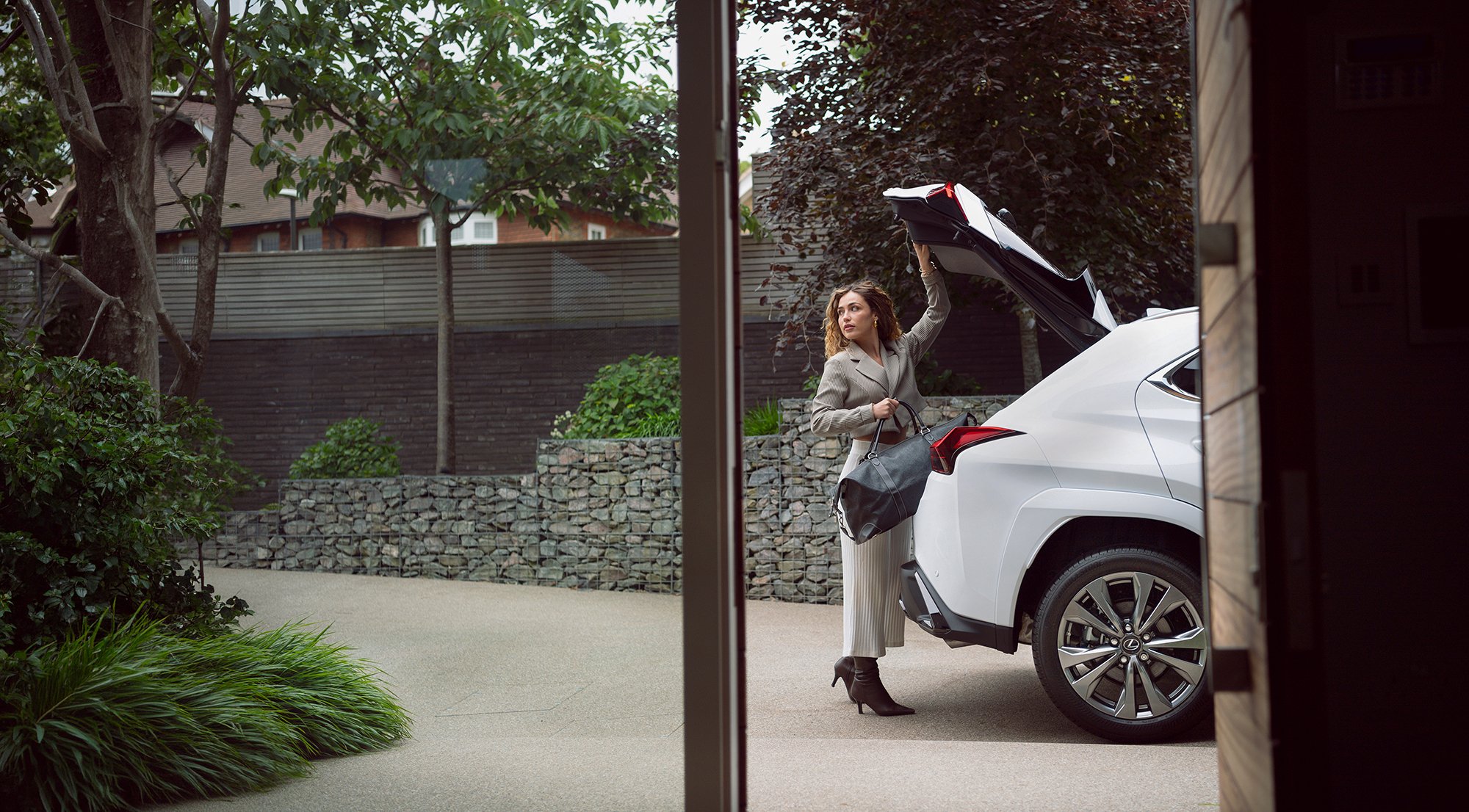 Woman placing a bag into a White Lexus, car photography.