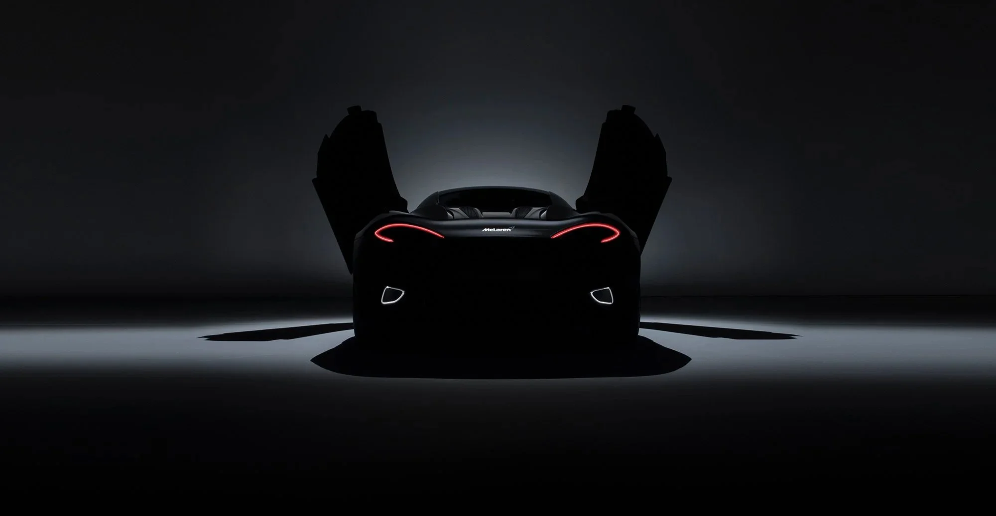 McLaren Car rear dramatic view in dark studio.