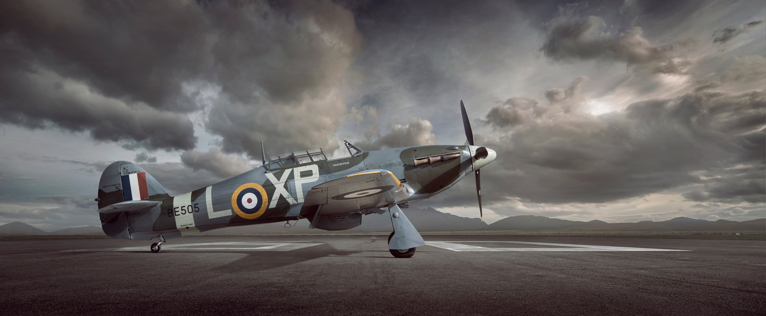 A WW2 Hurricane plane, side view sat on a runway.