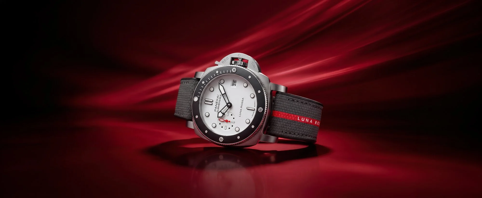 Watch in front of background of red dramatic swirls of light.
