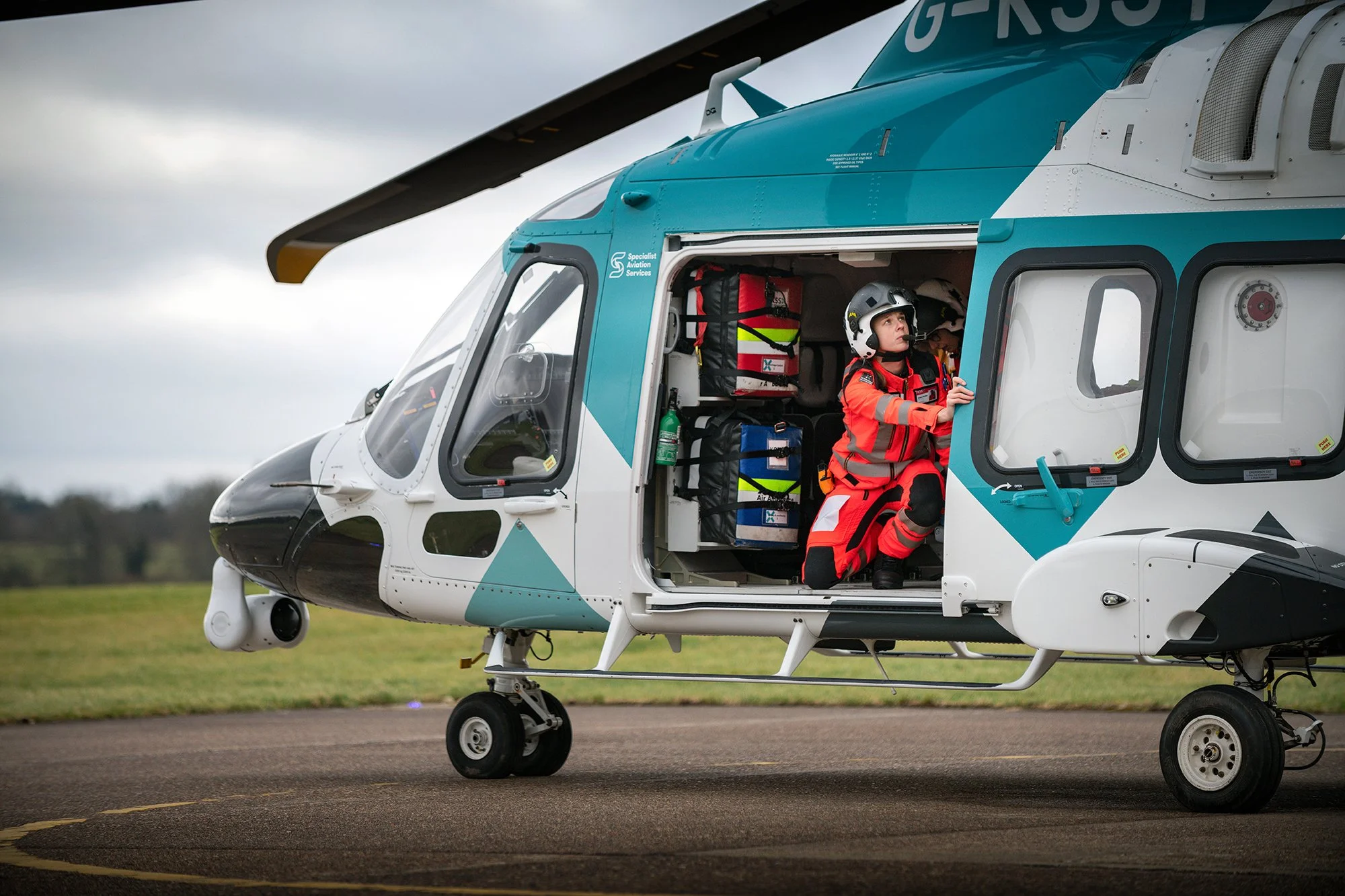 Kent Air Ambulance helicopter landed with doors being opened by paramedic.
