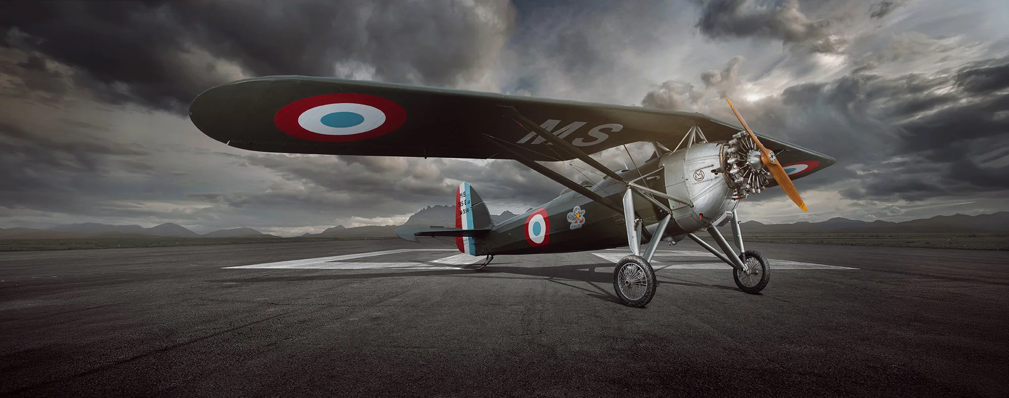 a vintage MS354 aircraft on a empty runway with a cloudy sky behind and the sun setting