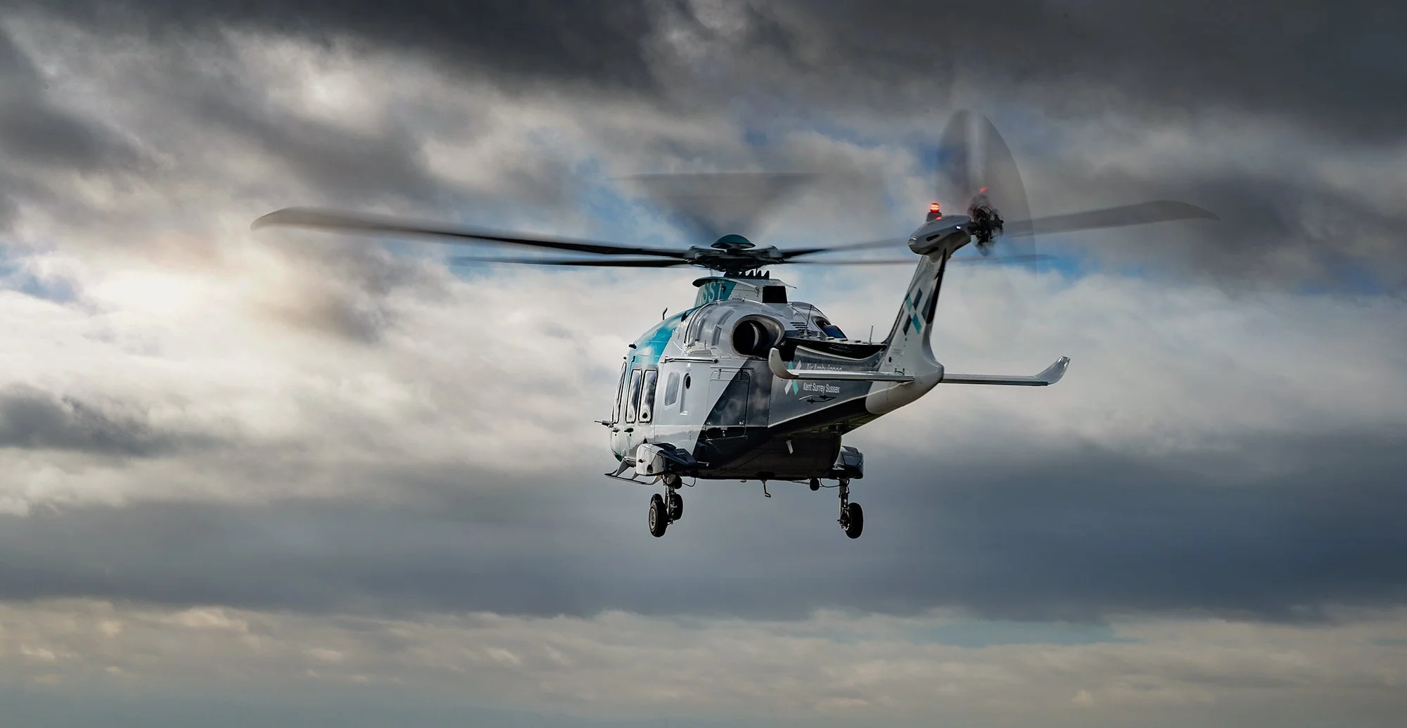 Kent Air Ambulance helicopter in flight from rear.