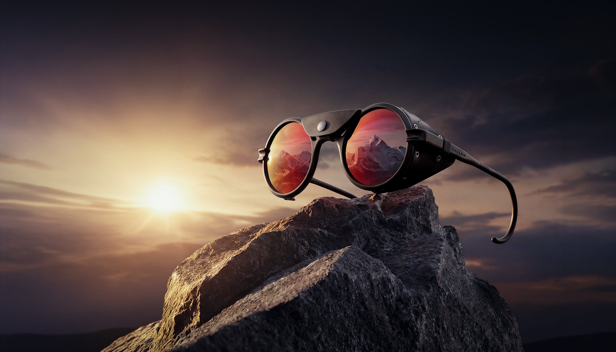 Sunglasses on top of mountain with sun setting