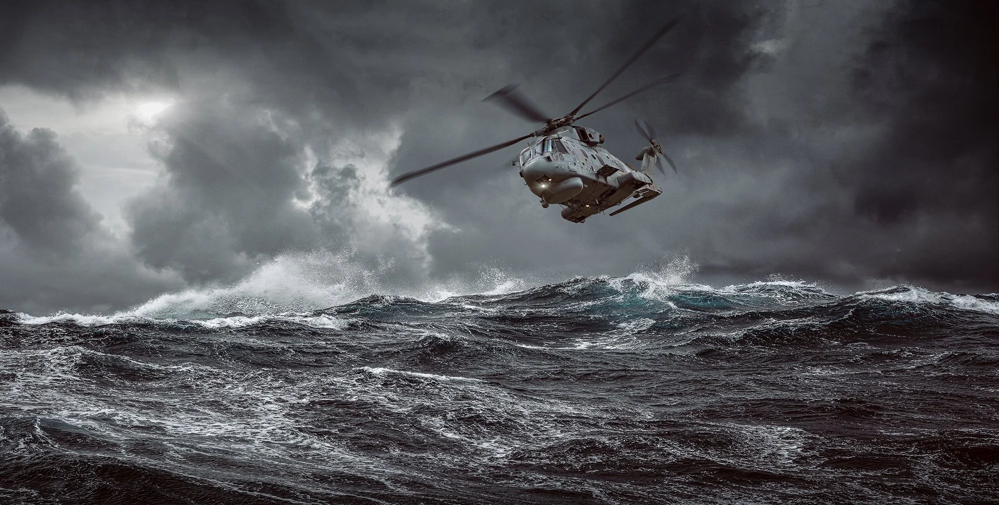 Merlin Helicopter flying over rough seas.