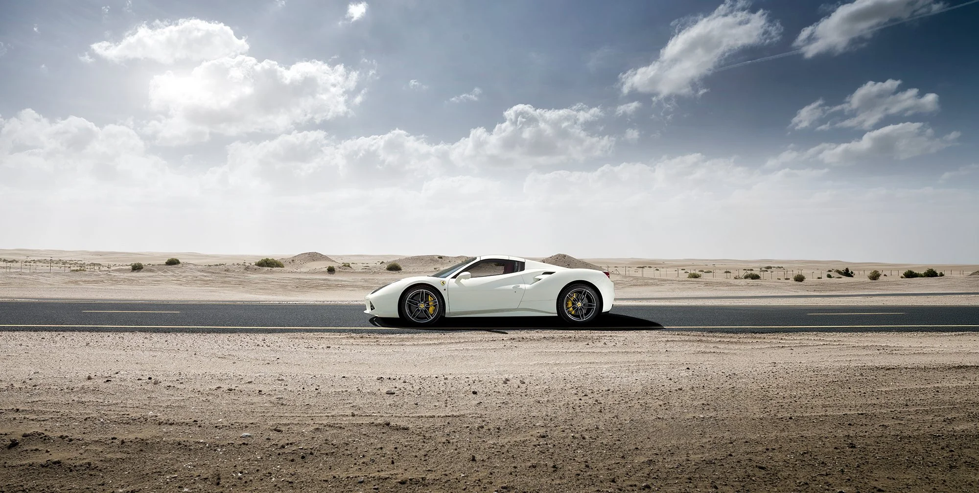 Ferrari, white in colour on road in desert.