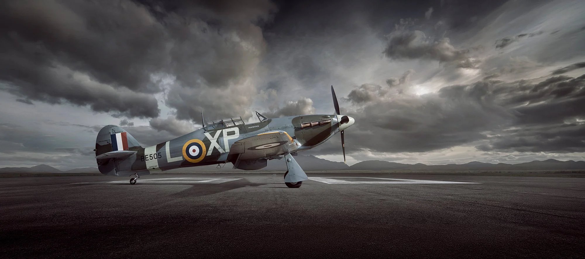 Hurricane warbird plane, side profile view on runway with dramatic sky behind. 