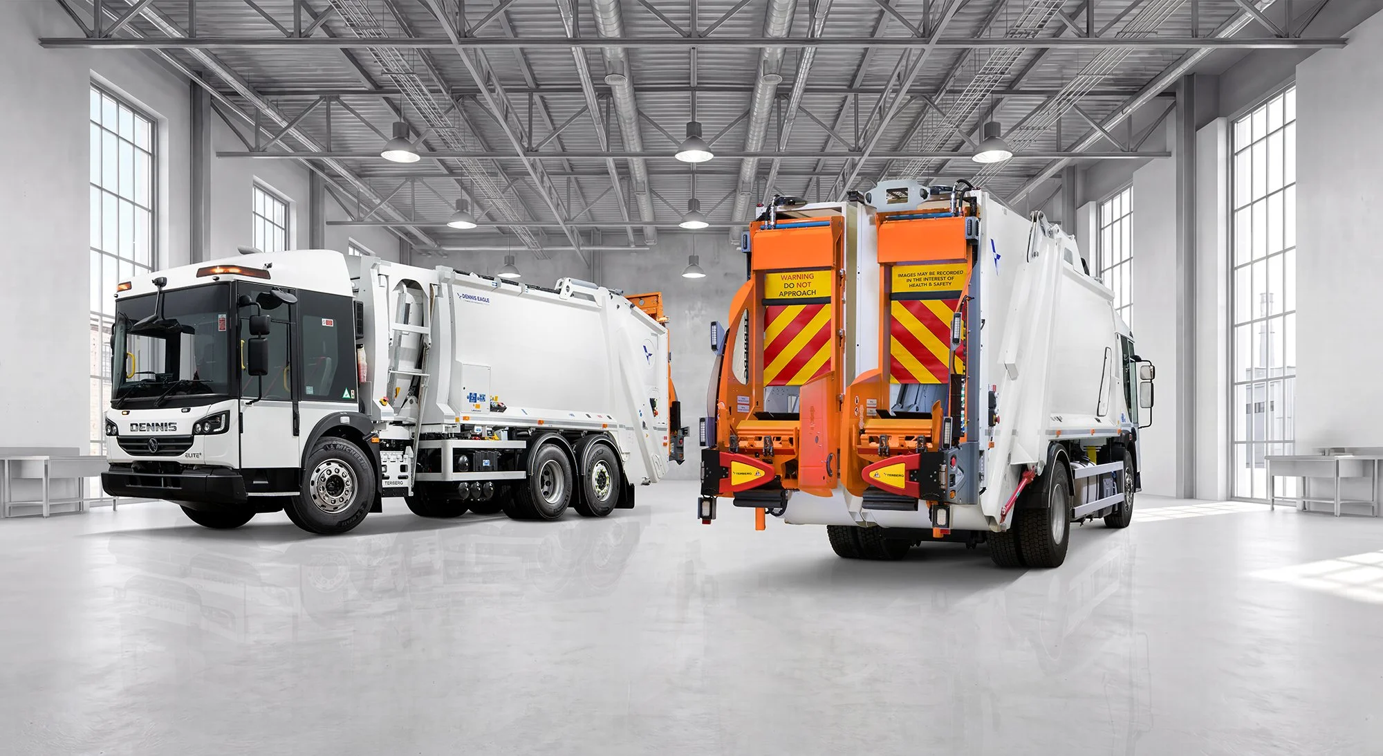 Dennis Eagle trucks in clean white factory space.