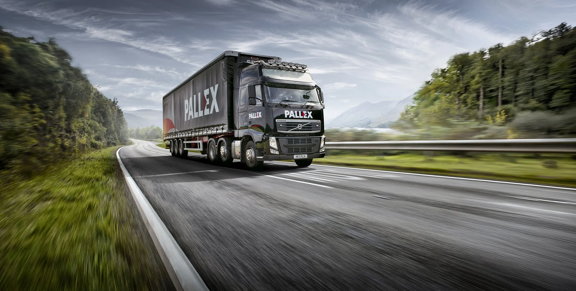 Logistics truck driving on open road.