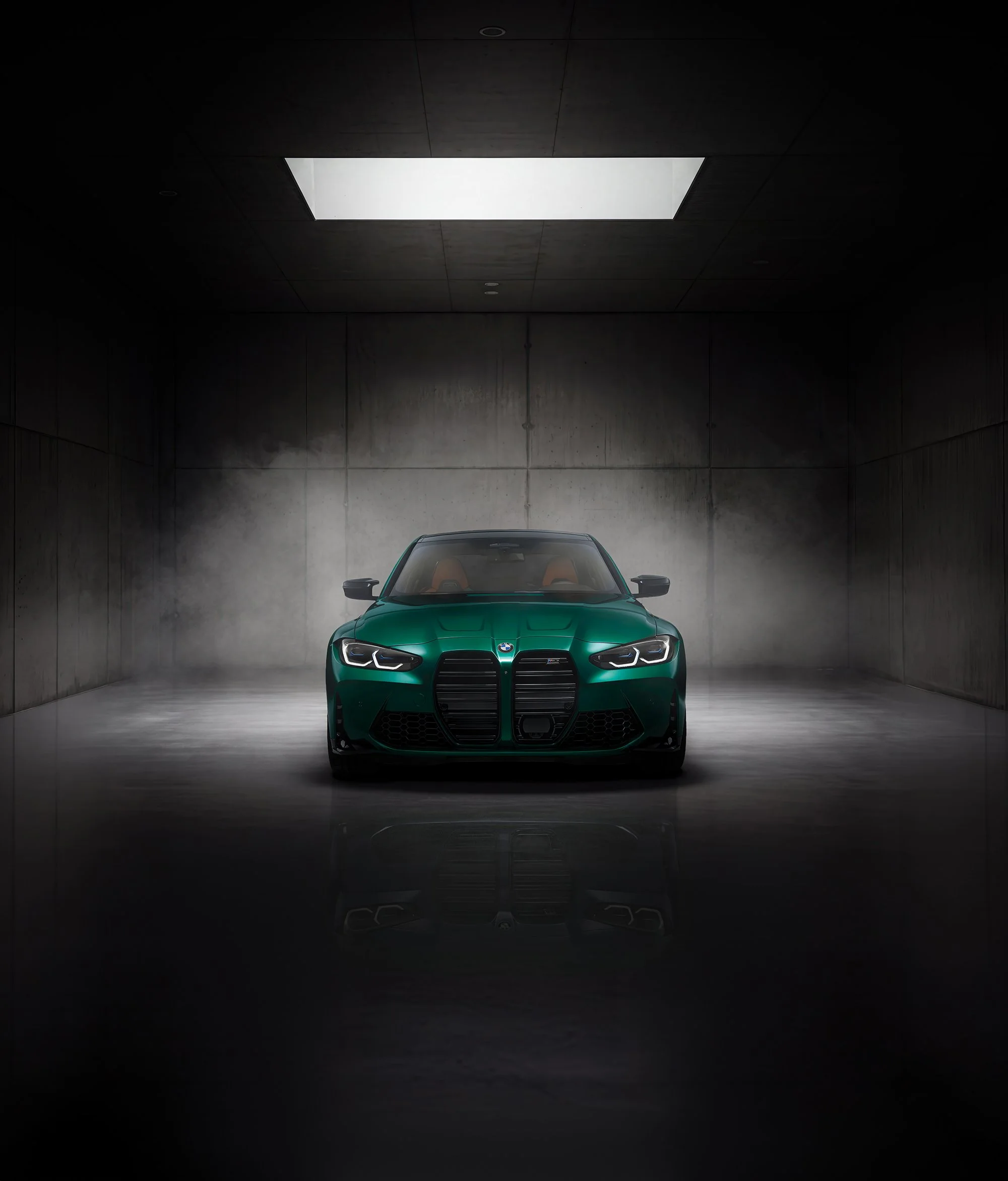 BMW M3 in dark green colour in dark concrete background. 