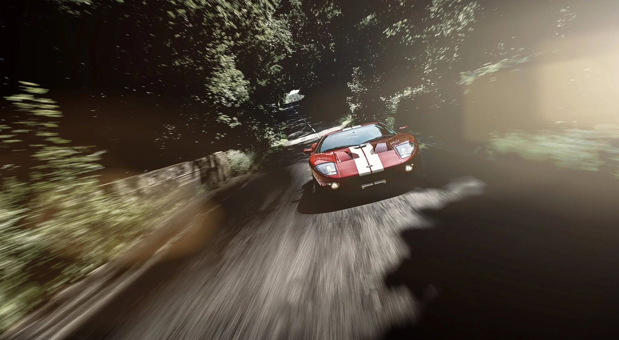 Ford GT in red racing on road through a wood