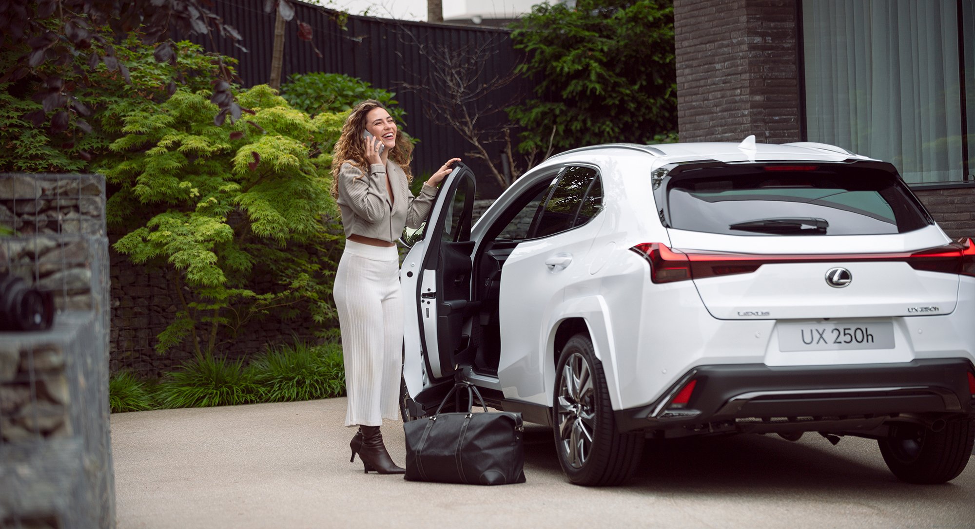 Woman talking on phone next to white Lexus, car photography