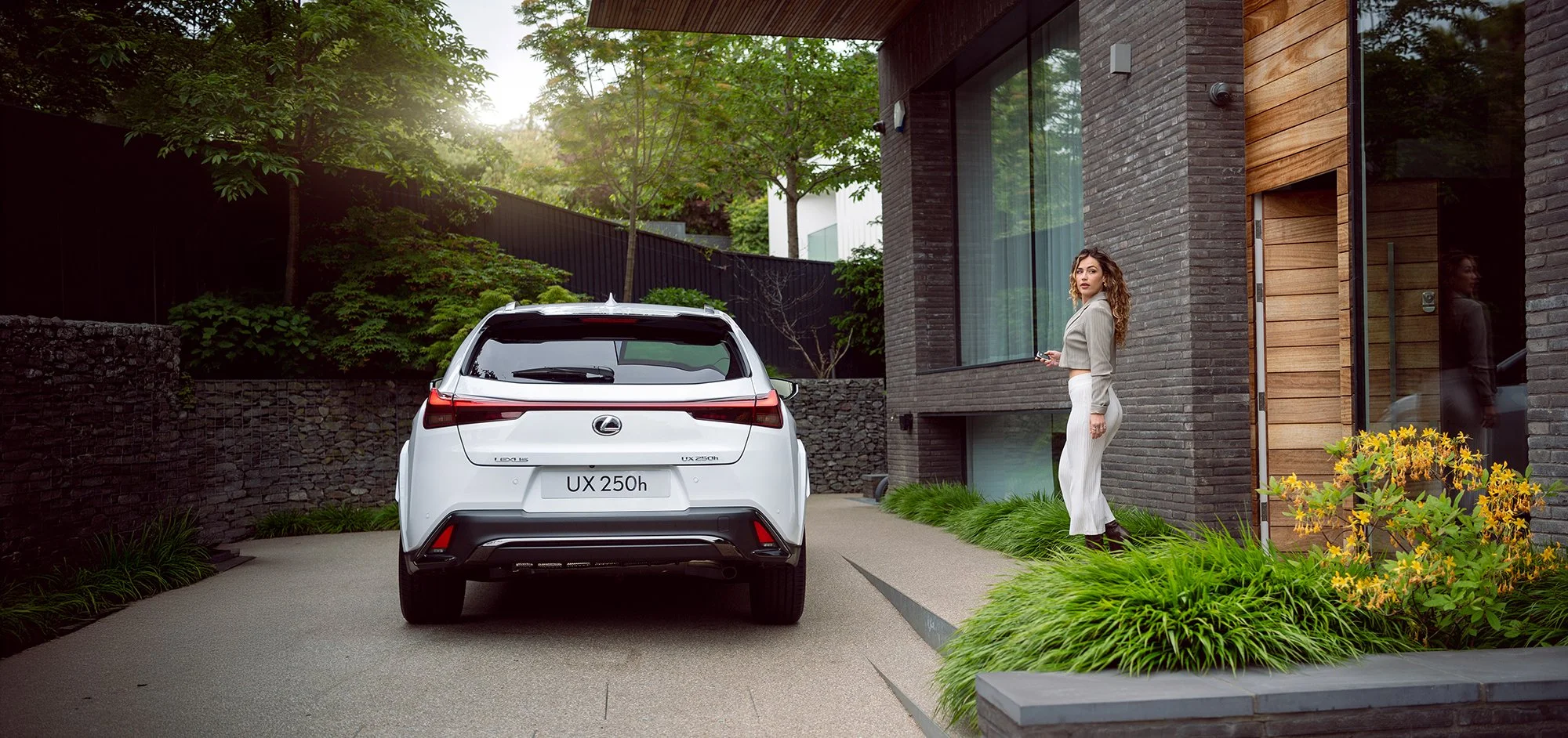 Woman walking towards white Lexus car.
