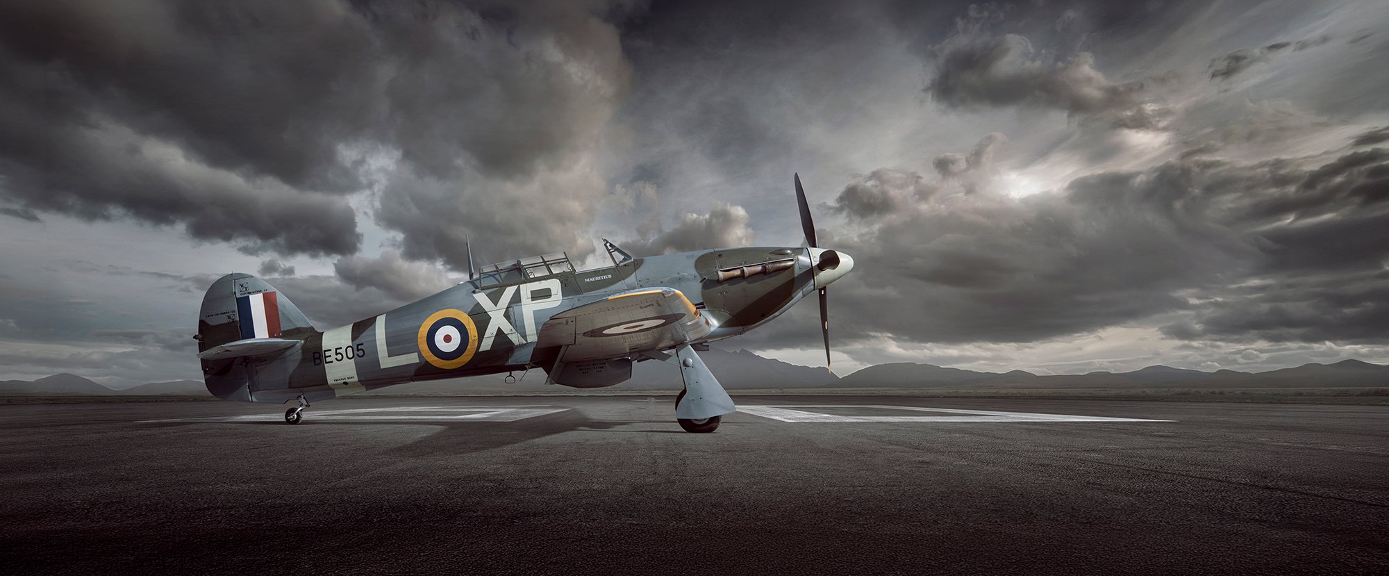 Hawker Hurricane aircraft on runway as the sun sets.
